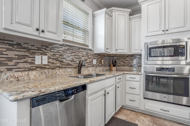 3841 Chateau Cv, Ocean Springs, MS 39564 - kitchen with appliances with stainless steel finishes, white cabinetry, tasteful backsplash, and crown molding