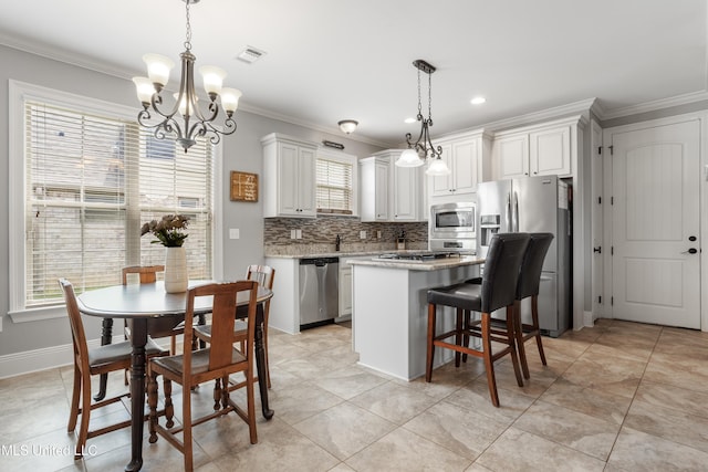 3841 Chateau Cv, Ocean Springs, MS 39564 - kitchen featuring stainless steel appliances, a chandelier, crown molding, decorative backsplash, and a center island