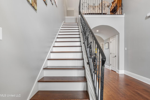 3841 Chateau Cv, Ocean Springs, MS 39564 - stairs with a high ceiling, arched walkways, and wood finished floors