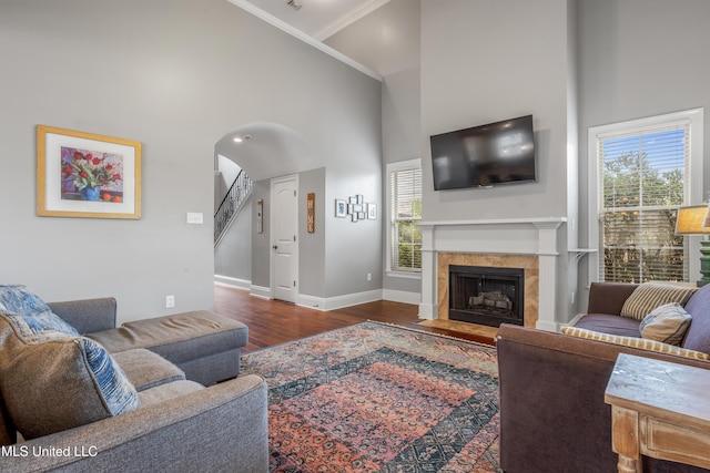 3841 Chateau Cv, Ocean Springs, MS 39564 - living room featuring a towering ceiling, a fireplace with flush hearth, wood finished floors, healthy amount of natural light, and crown molding