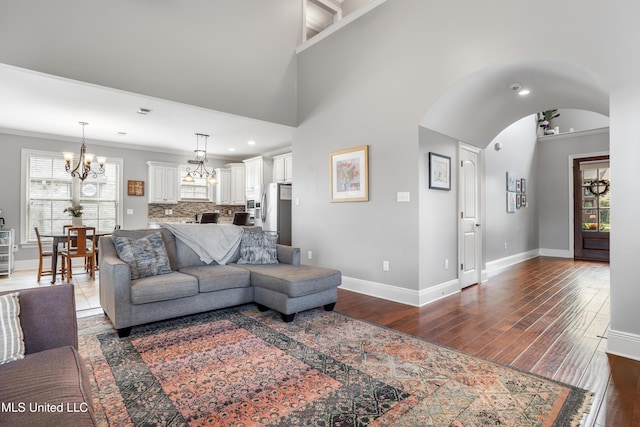 3841 Chateau Cv, Ocean Springs, MS 39564 - living area featuring a chandelier, arched walkways, plenty of natural light, dark wood-type flooring, and crown molding