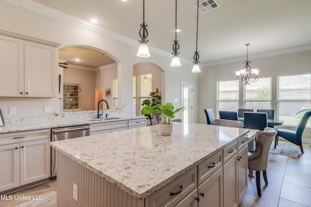 3936 David Ln, Diberville, MS 39540 - kitchen featuring a sink, a center island, arched walkways, light stone countertops, and crown molding
