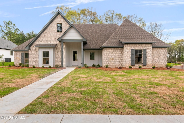 view of front of property featuring central AC and a front yard