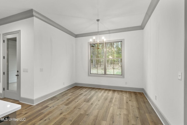 unfurnished dining area with crown molding, hardwood / wood-style flooring, and a chandelier