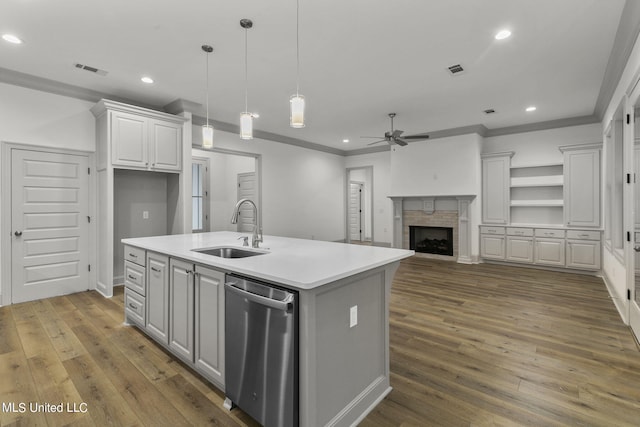 kitchen with white cabinets, an island with sink, dishwasher, dark wood-type flooring, and sink