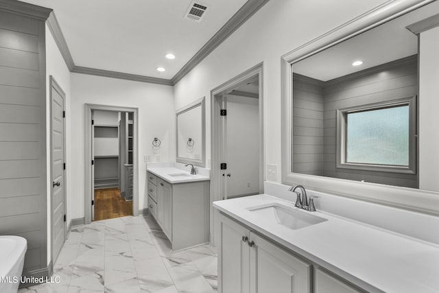 bathroom featuring vanity, crown molding, and a washtub