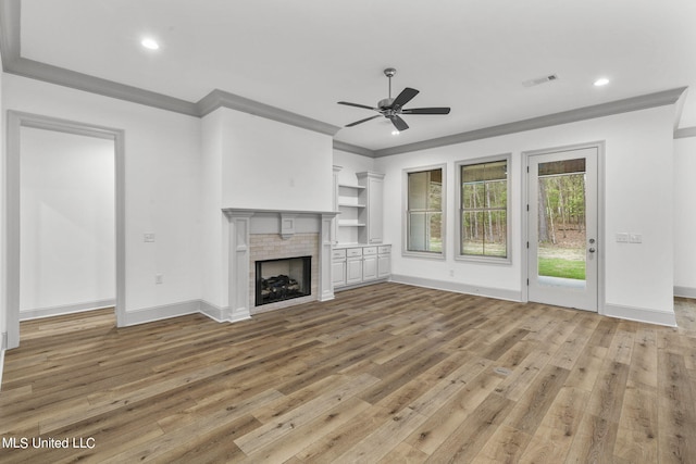 unfurnished living room with ceiling fan, ornamental molding, and light wood-type flooring