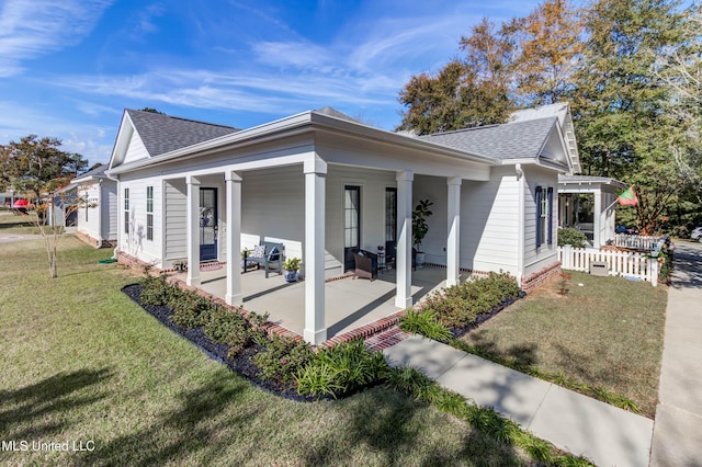 view of side of property with a lawn and covered porch