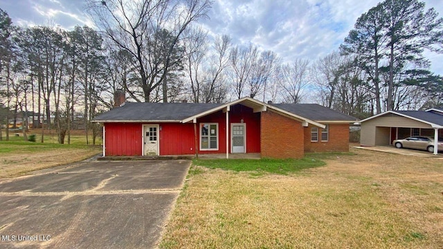 ranch-style house featuring a carport and a front lawn