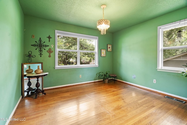 530 Oakhurst Dr, Hernando, MS 38632 - spare room featuring healthy amount of natural light, wood finished floors, and a chandelier