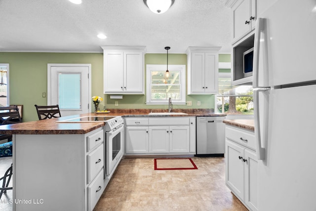 530 Oakhurst Dr, Hernando, MS 38632 - kitchen with stainless steel appliances, a peninsula, white cabinetry, dark countertops, and a textured ceiling