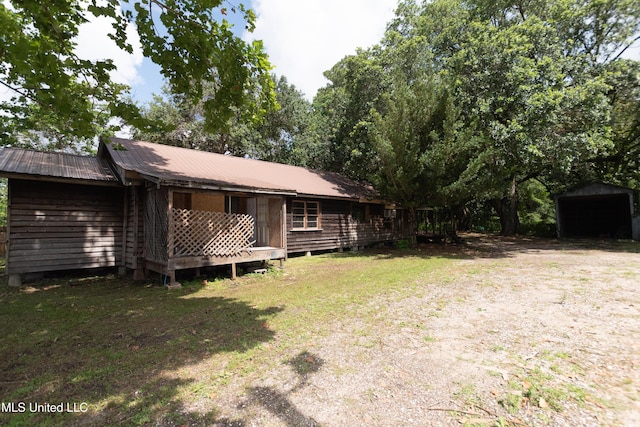 5619 Grierson St, Moss Point, MS 39563 - back of house with a metal roof, an outdoor structure, and a yard