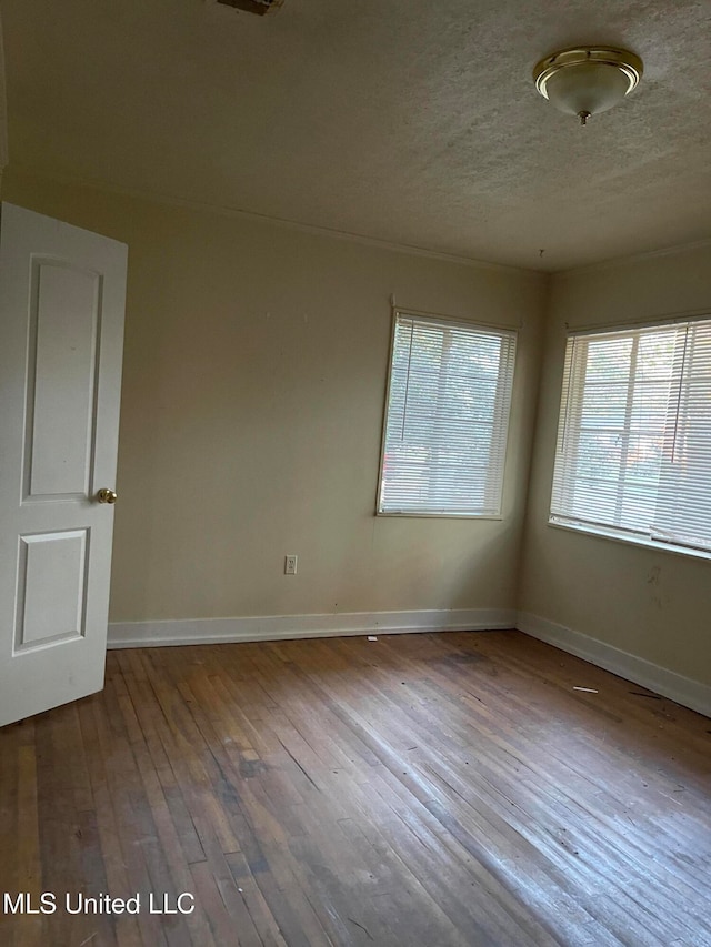 spare room with wood-type flooring and a textured ceiling