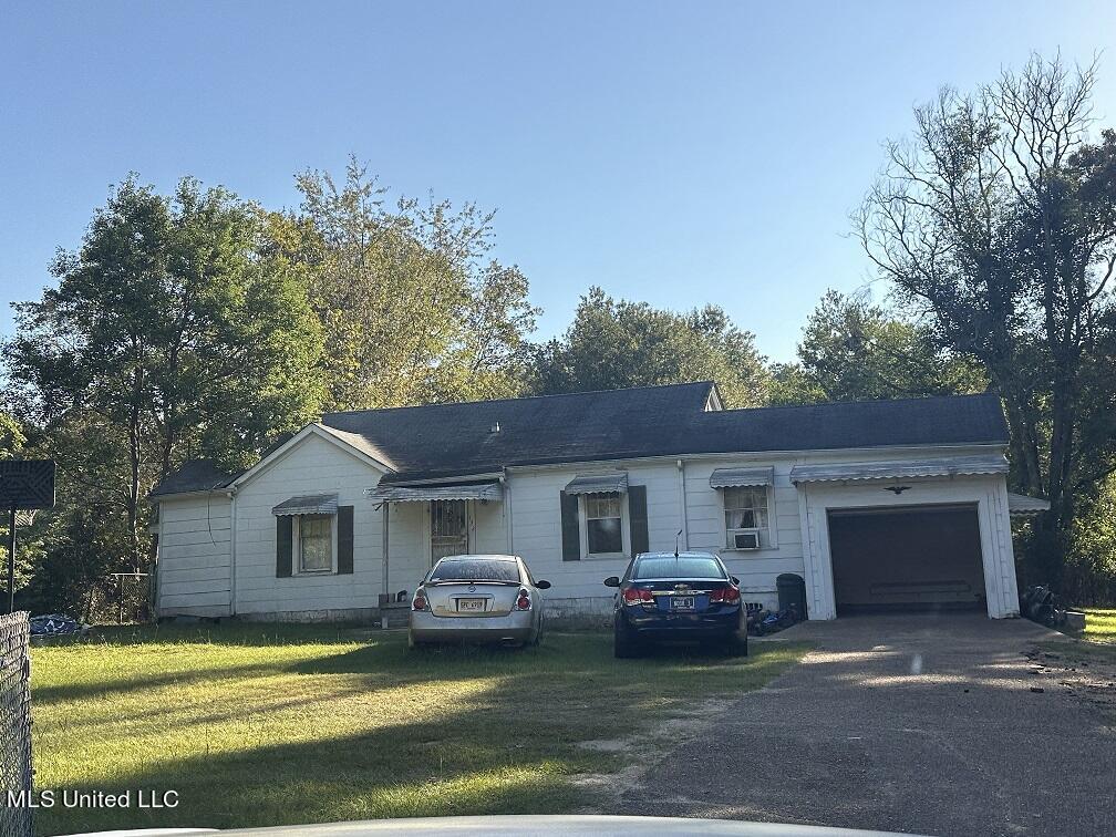 single story home featuring a front yard and a garage