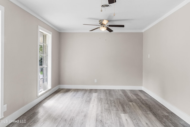 spare room with ceiling fan, crown molding, a wealth of natural light, and hardwood / wood-style floors