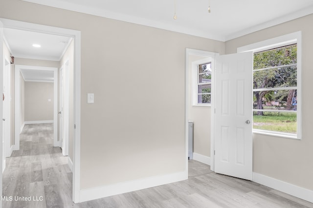 unfurnished room featuring ornamental molding and light hardwood / wood-style flooring