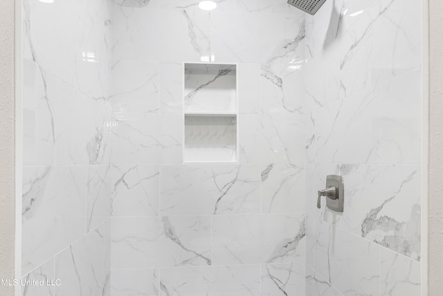 interior details featuring a tile shower