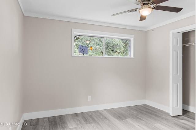 unfurnished bedroom with a closet, ceiling fan, crown molding, and light hardwood / wood-style floors