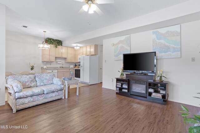 living room featuring baseboards, ceiling fan, visible vents, and wood finished floors