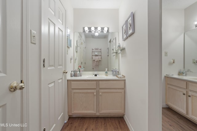bathroom with vanity, baseboards, and wood finished floors