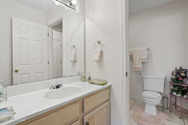 bathroom with toilet, tile patterned flooring, and vanity