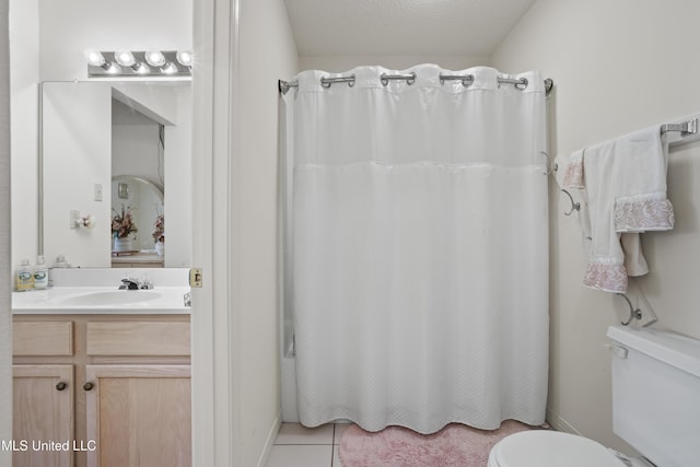 bathroom with vanity, baseboards, tile patterned floors, and toilet