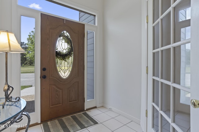 foyer entrance featuring baseboards and light tile patterned floors