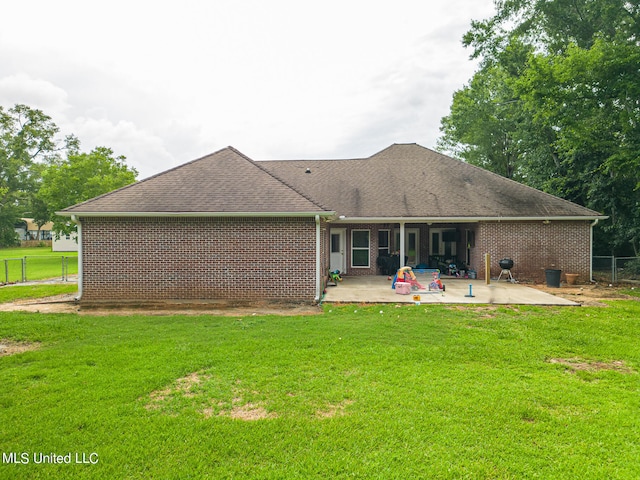 back of house with a yard and a patio