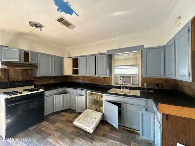 kitchen with gray cabinetry, backsplash, sink, gas range gas stove, and dishwashing machine