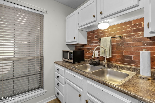 7012 Copper Cv, Ridgeland, MS 39157 - kitchen featuring stainless steel microwave, a sink, dark countertops, white cabinets, and tasteful backsplash