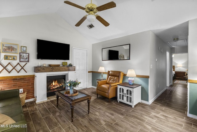 7012 Copper Cv, Ridgeland, MS 39157 - living room with ceiling fan, wood finished floors, baseboards, vaulted ceiling, and a warm lit fireplace