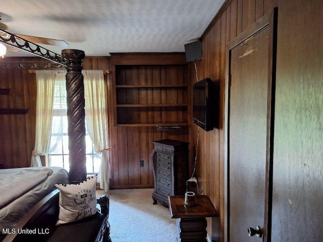 interior space featuring wood walls, a textured ceiling, and light colored carpet