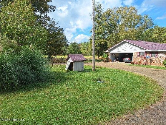 view of yard featuring a storage unit and a carport