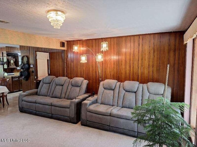 home theater with a chandelier, carpet flooring, and wood walls