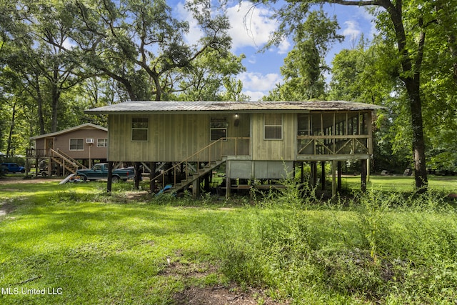 back of property featuring a yard and a sunroom