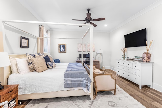 bedroom with light hardwood / wood-style floors, ceiling fan, and ornamental molding