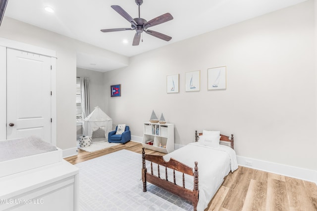 bedroom featuring ceiling fan, a closet, and light hardwood / wood-style flooring