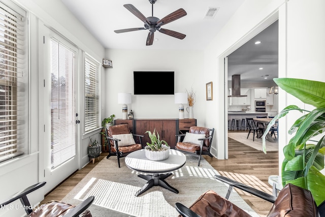 living room featuring ceiling fan and light wood-type flooring