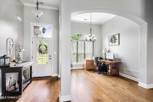 6865 Payne Ln, Olive Branch, MS 38654 - entryway featuring crown molding, arched walkways, wood finished floors, and a chandelier