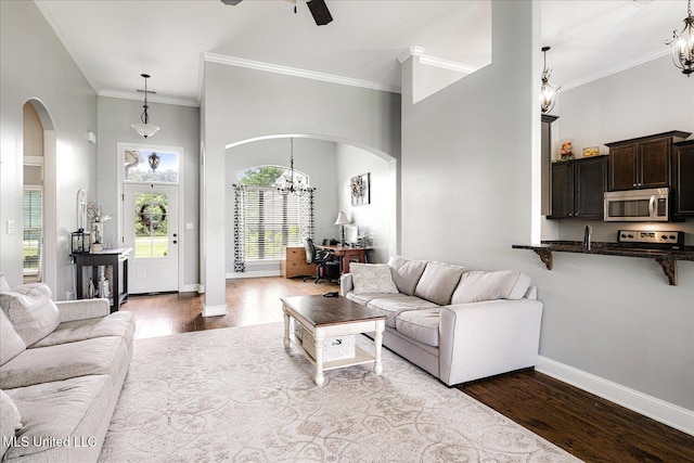 6865 Payne Ln, Olive Branch, MS 38654 - living room with arched walkways, an office area, dark wood-style flooring, a chandelier, and ornamental molding