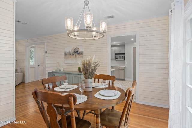 dining room featuring ornamental molding, a chandelier, and light hardwood / wood-style flooring