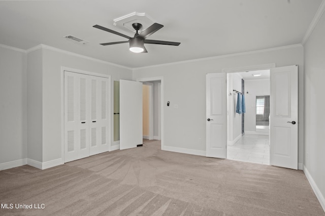 unfurnished bedroom featuring light carpet, ceiling fan, connected bathroom, a closet, and crown molding