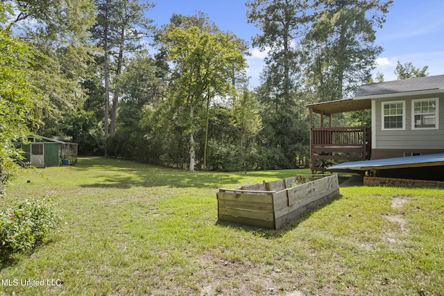 view of yard featuring a storage unit and a wooden deck