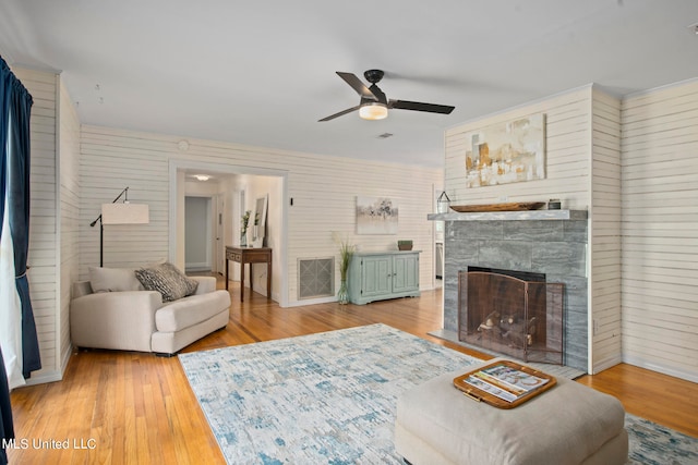 living room with hardwood / wood-style floors, a fireplace, and ceiling fan