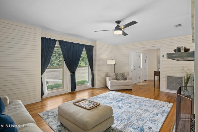 living room with ceiling fan, a fireplace, and hardwood / wood-style floors