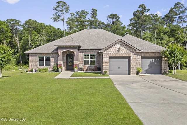 14463 Aerie Rd, Gulfport, MS 39503 - french country home with brick siding, a shingled roof, a garage, and concrete driveway