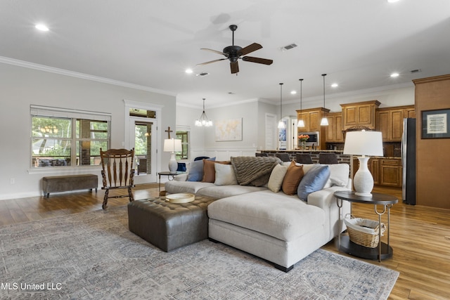 14463 Aerie Rd, Gulfport, MS 39503 - living room with a ceiling fan, recessed lighting, light wood-style floors, ornamental molding, and a chandelier
