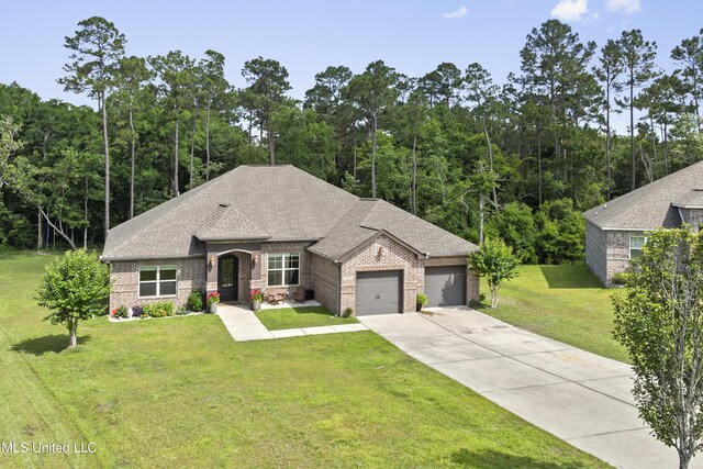14463 Aerie Rd, Gulfport, MS 39503 - french country style house with brick siding, concrete driveway, a front yard, a garage, and a shingled roof