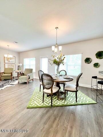 dining room with wood-type flooring and an inviting chandelier