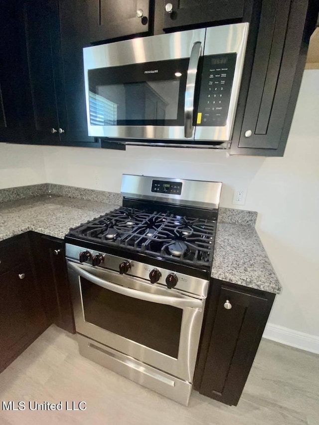 kitchen featuring light stone counters and stainless steel appliances